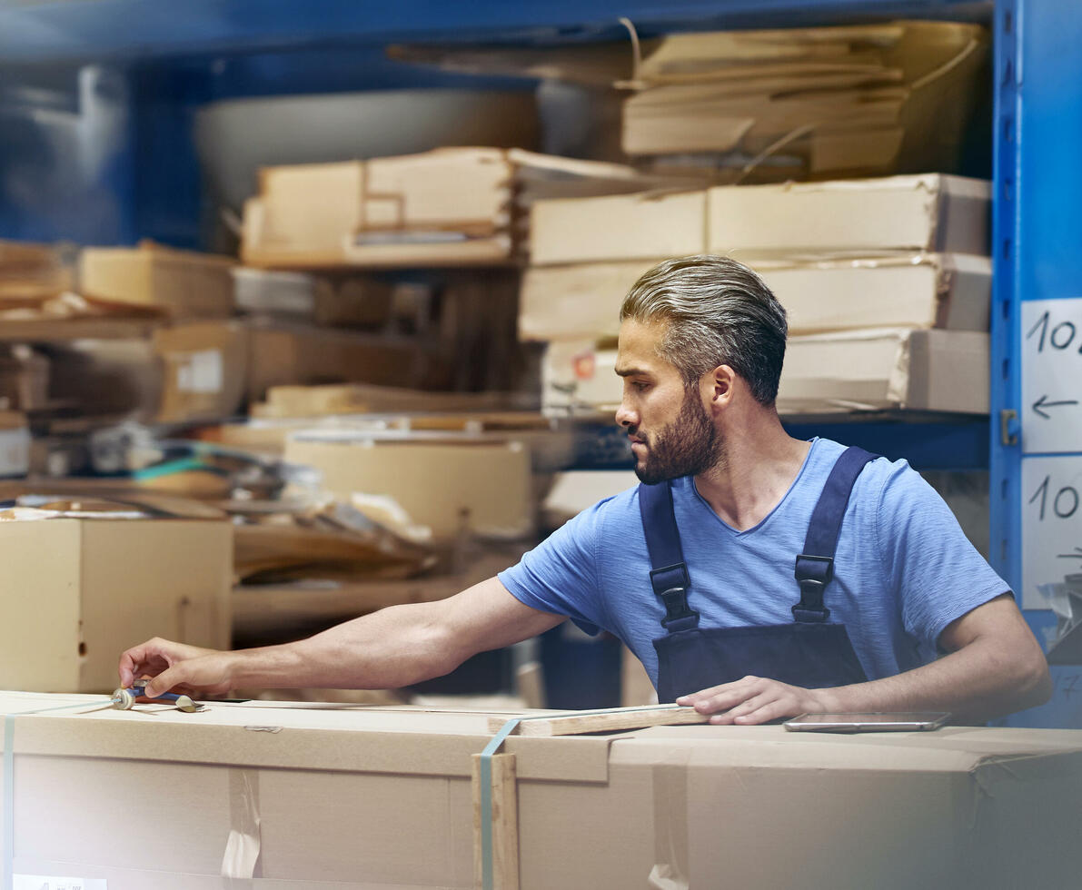 male busy with parcels in a distribution center/warehouse.
male busy with parcels in a distribution center/warehouse.