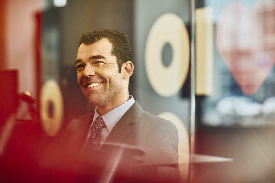 Close up - Man smiling looking away, at the office.