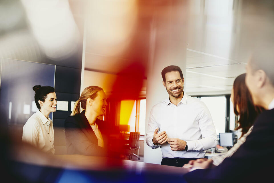 Business men and women in an office having a meeting.